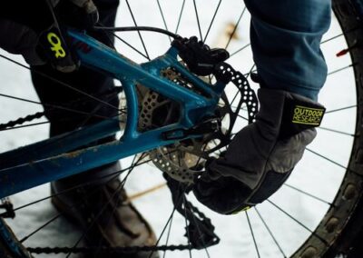 Trusted bicycle repair and accessories in LA by The Bike Man Services, mechanic fixing a bike while displaying high-quality gear